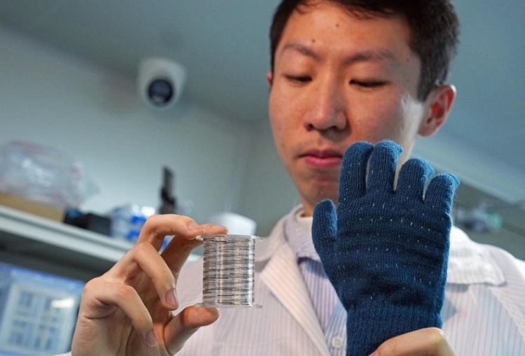 исследователь демонстрирует свернутые в рулон «волоконные чипы» и «умную» тактильную перчатку